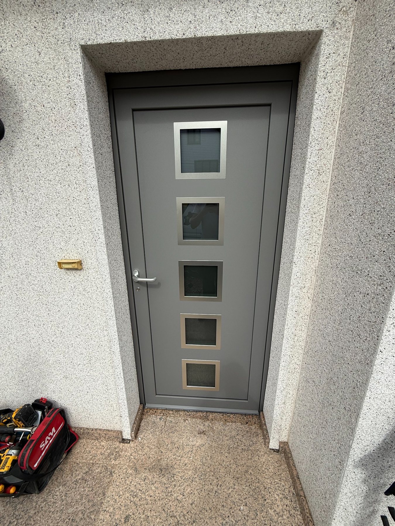 Porte d'entrée grise avec cinq vitrages